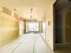 リノベーション工事中のリビングダイニング。バルコニーに面した大きな窓から自然光が差し込み、明るく開放的な空間に仕上がる予定です。完成後はゆとりあるLDKとして、家族でくつろげる住空間になります。