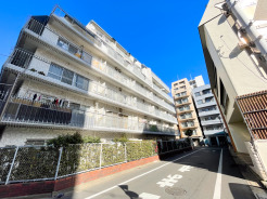 マンション前面は交通量の少ない落ち着いた道路で、静かな住環境が保たれています。建物全体は白を基調とした外観で、周囲の街並みにも調和。日中は陽当たりも良く、開放感のあるロケーションです。