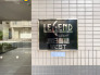 「レジェンド東日暮里WEST」の館銘板です。手入れの行き届いたエントランスと上質感のあるデザインが、住まう方や訪れる方を心地よく迎えてくれるマンションです。